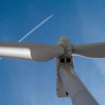 Jet Plane Flying over Wind Turbine