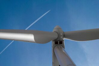 Jet Plane Flying over Wind Turbine