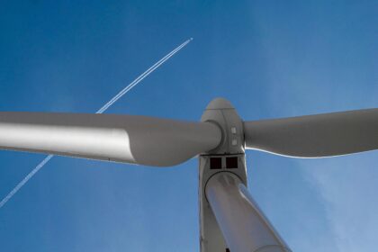 Jet Plane Flying over Wind Turbine