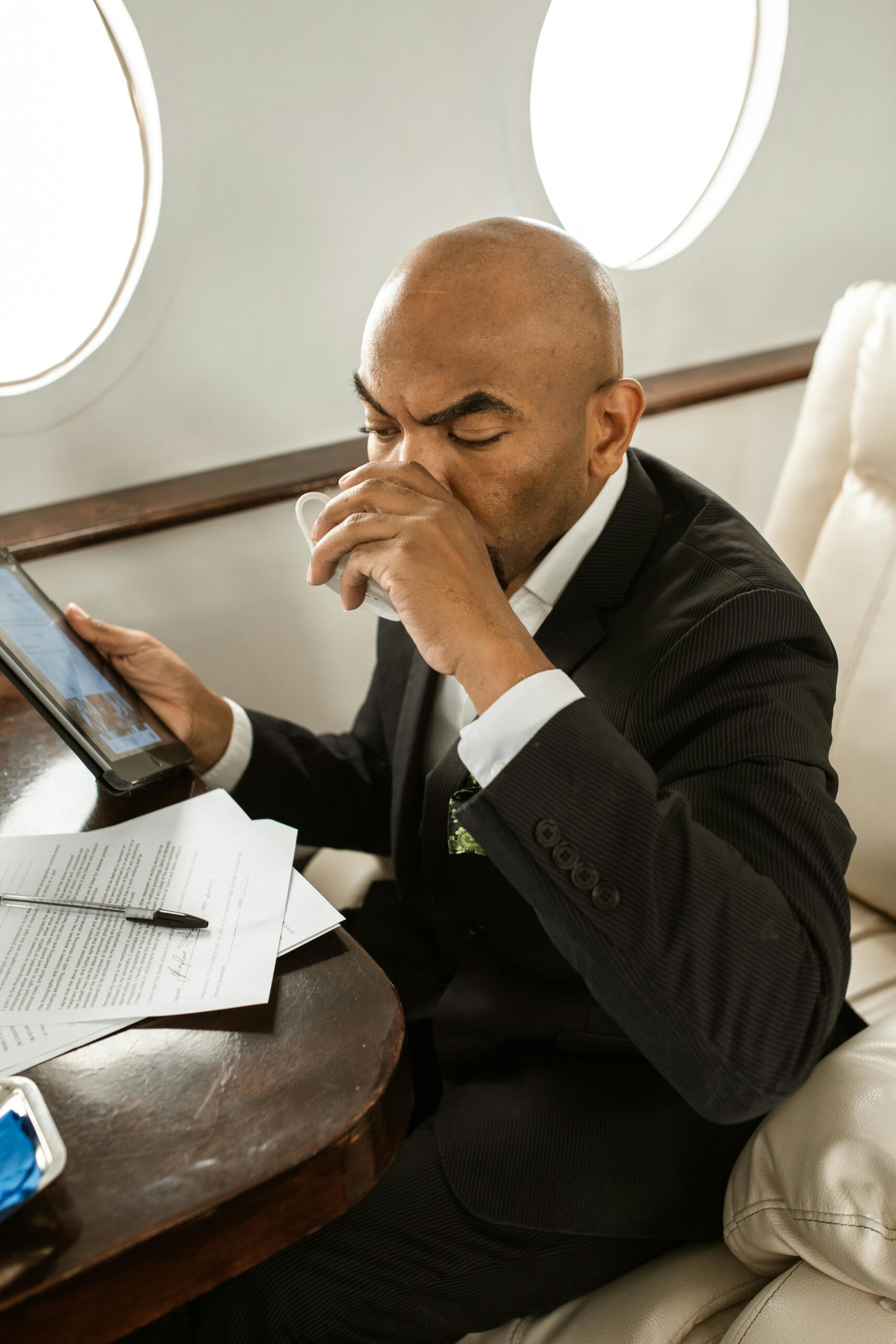 A Man Sipping his Drink in an Airplane
