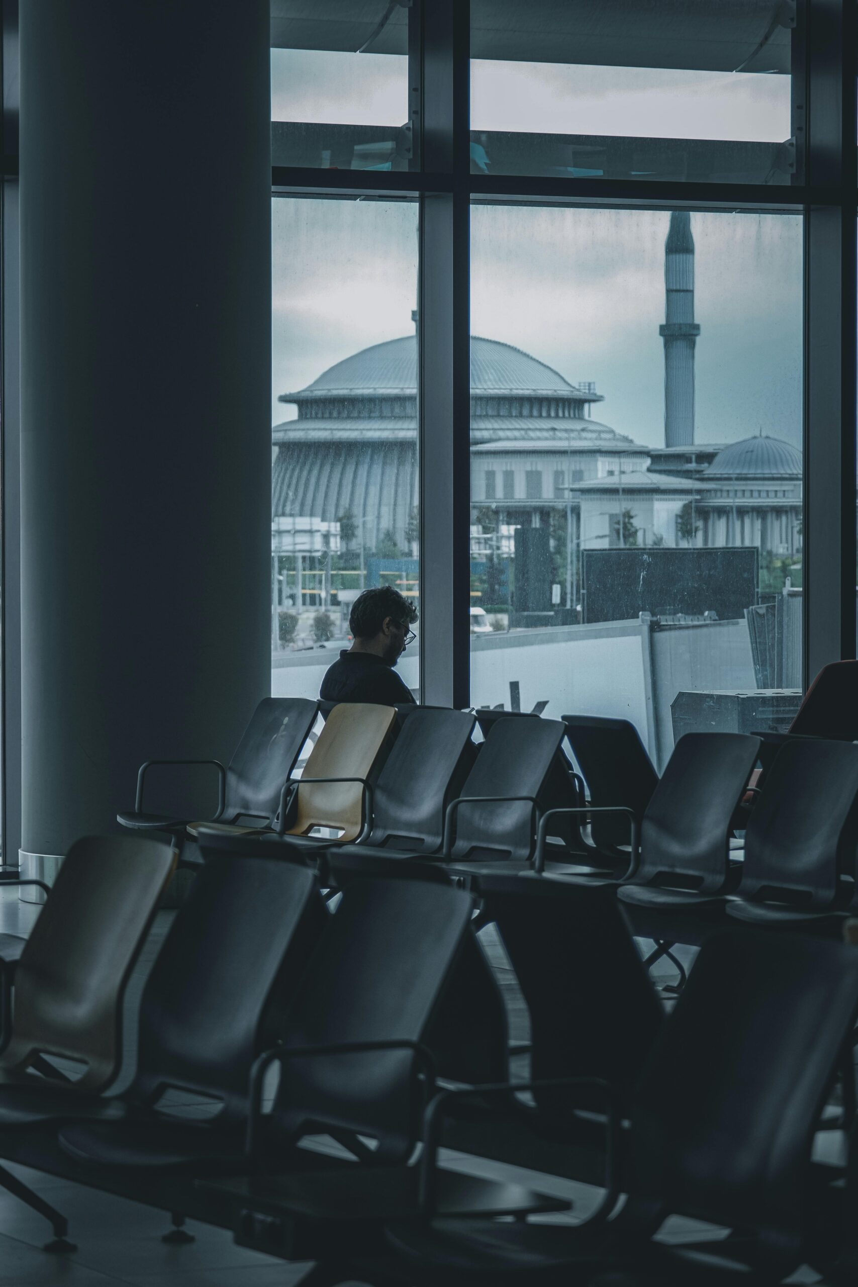 A man sat next to the window at the airport 