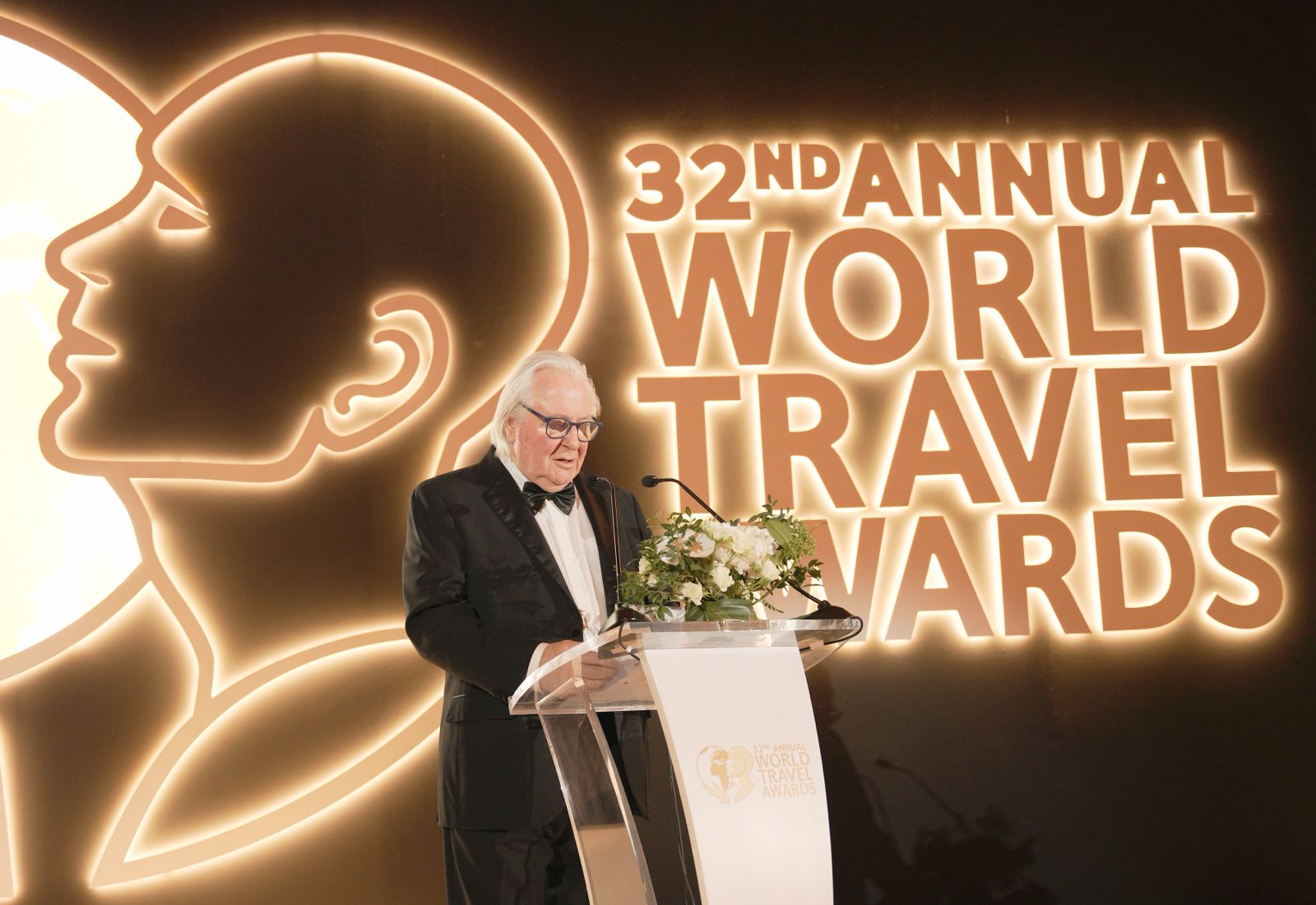 A large elderly man presenting the awards during the World Travel Awards (WTA) in their 32nd Annual Event.