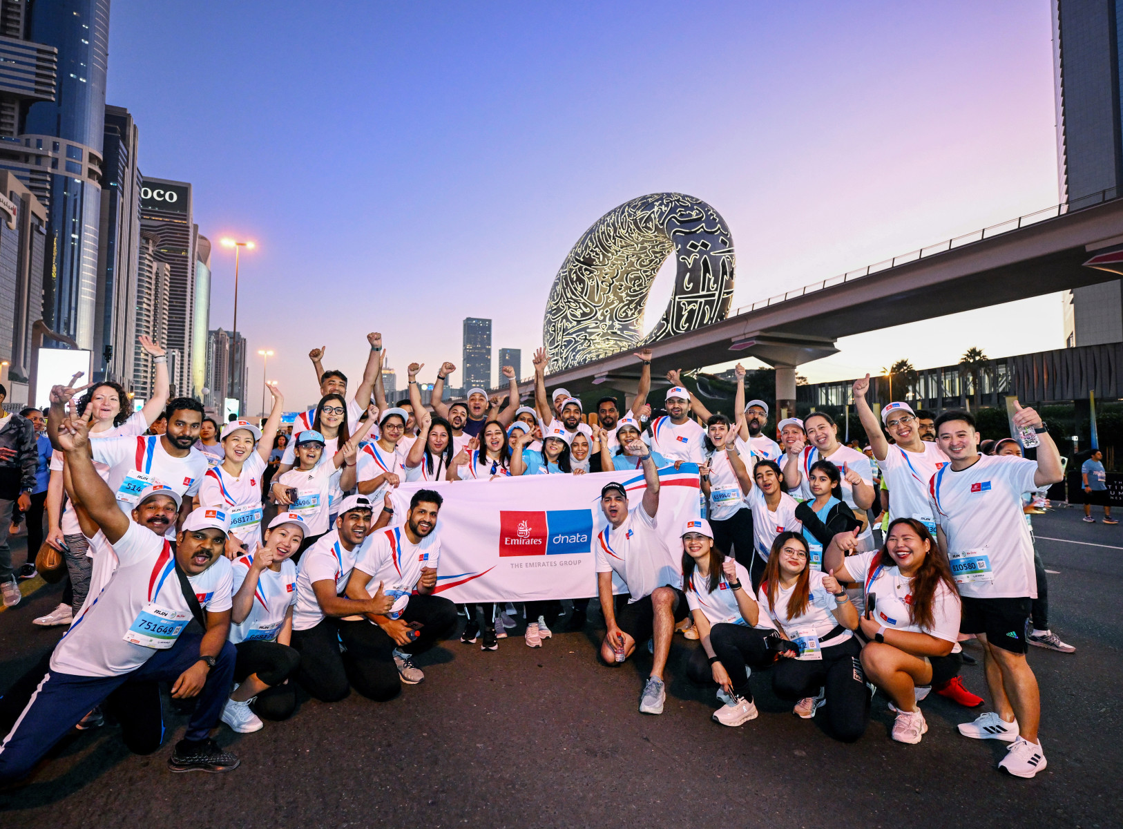 Emirates Group Employees at Dubai run celebrating around a banner