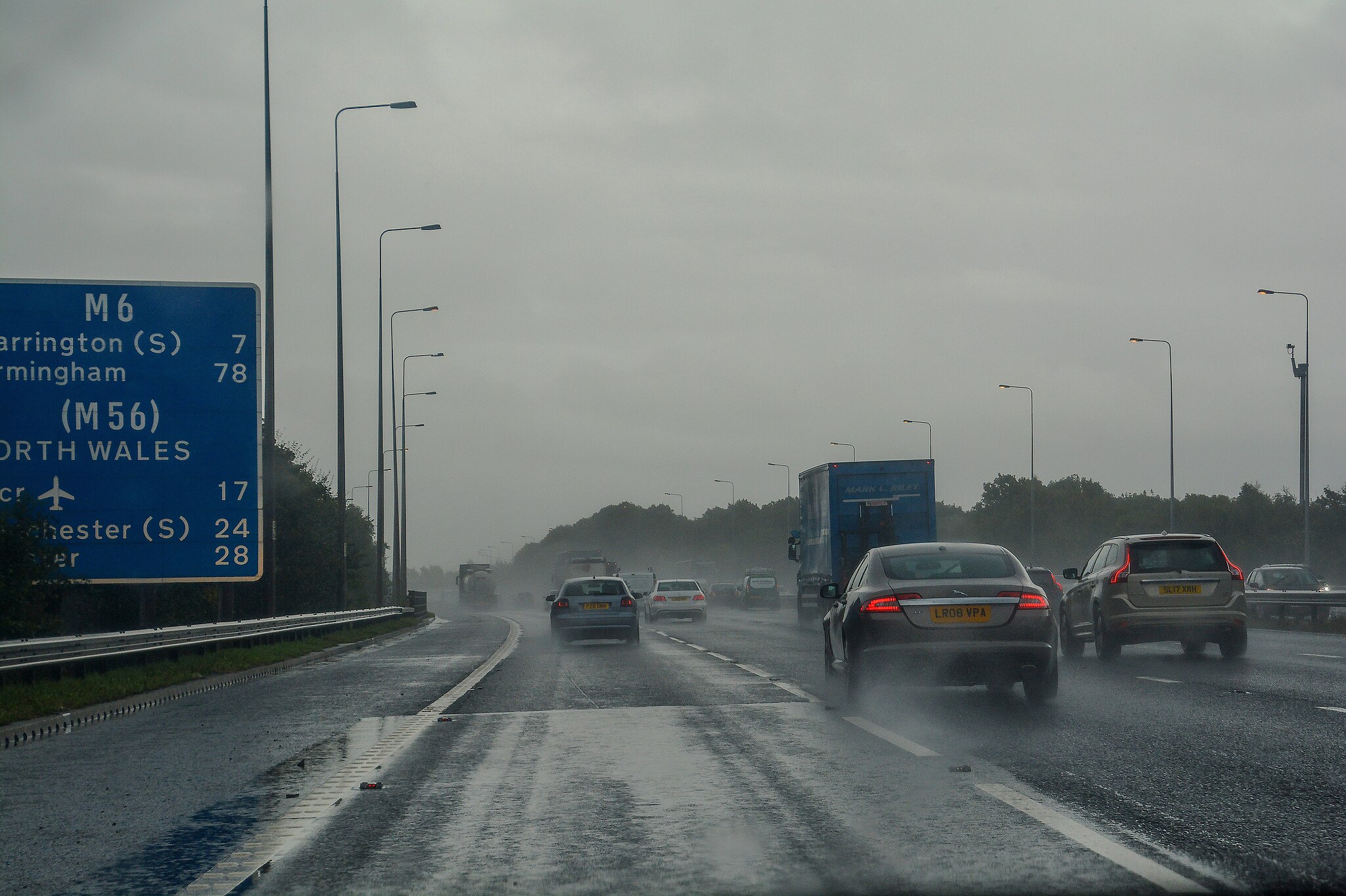 A rainy motorway with cars headed towards Manchester.