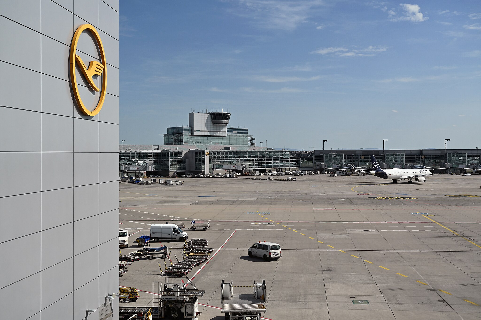 A view of Concourse A of Terminal 1 from Concourse A-Z, with Lufthansa logo, Frankfurt Airport. There is one Lufthansa aircraft taxiing to the runway.