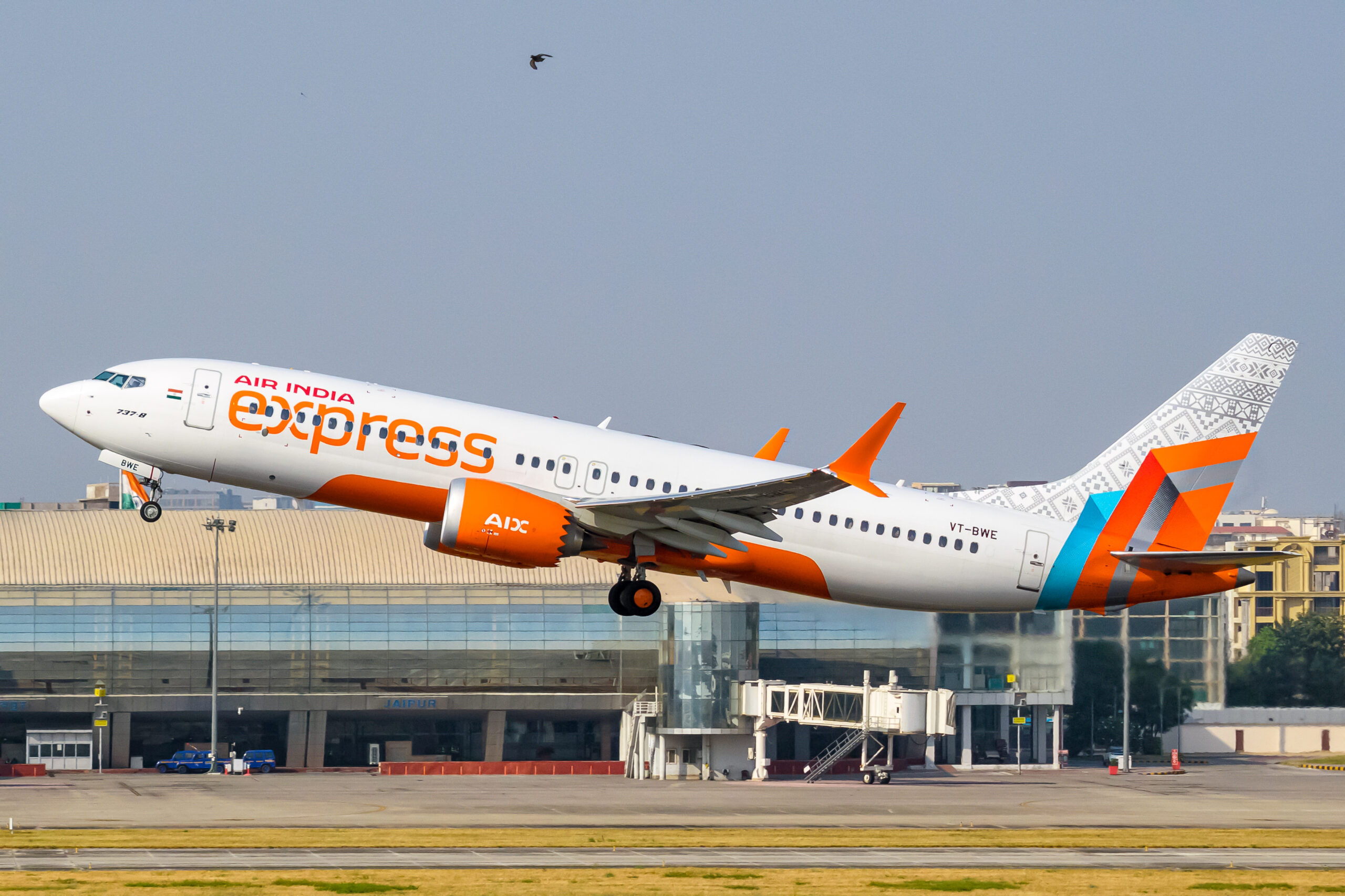 A new custom Boeing 737-8 MAX with the Air India Express logo, taking off from the runway.