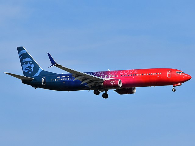 An Alaska Airlines Boeing 737-900(ER) is on final approach to Newark Liberty International Airport, passing over Interstate 78 and Port Street in the North Area.