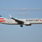 An American Airlines Boeing 737 flying in the sky with some clouds.