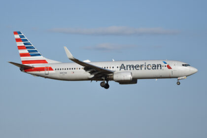 An American Airlines Boeing 737 flying in the sky with some clouds.
