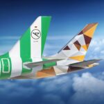 Tails of Condor and Etihad aircraft flying in the sky, showcasing both airlines’ branding.