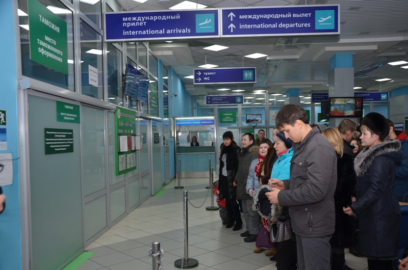 People standing in front of the customs section in an airport