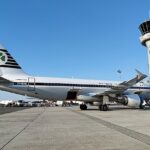 Aer Lingus Airbus A320 parked underneath the control tower.