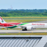 A Royal Air Maroc Boeing 787-9 Dreamliner is rolling for takeoff at John F. Kennedy International Airport, with blue sky.
