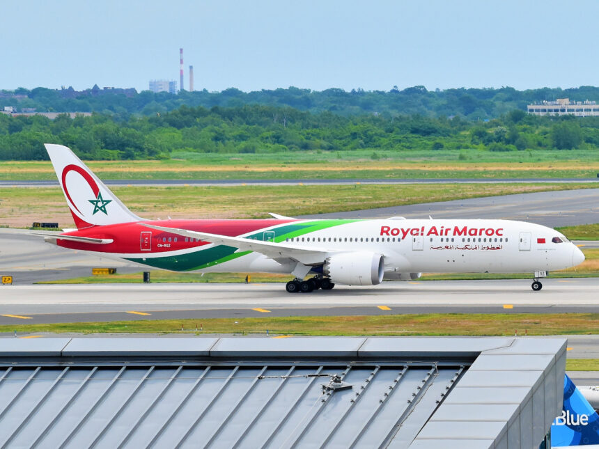 A Royal Air Maroc Boeing 787-9 Dreamliner is rolling for takeoff at John F. Kennedy International Airport, with blue sky.