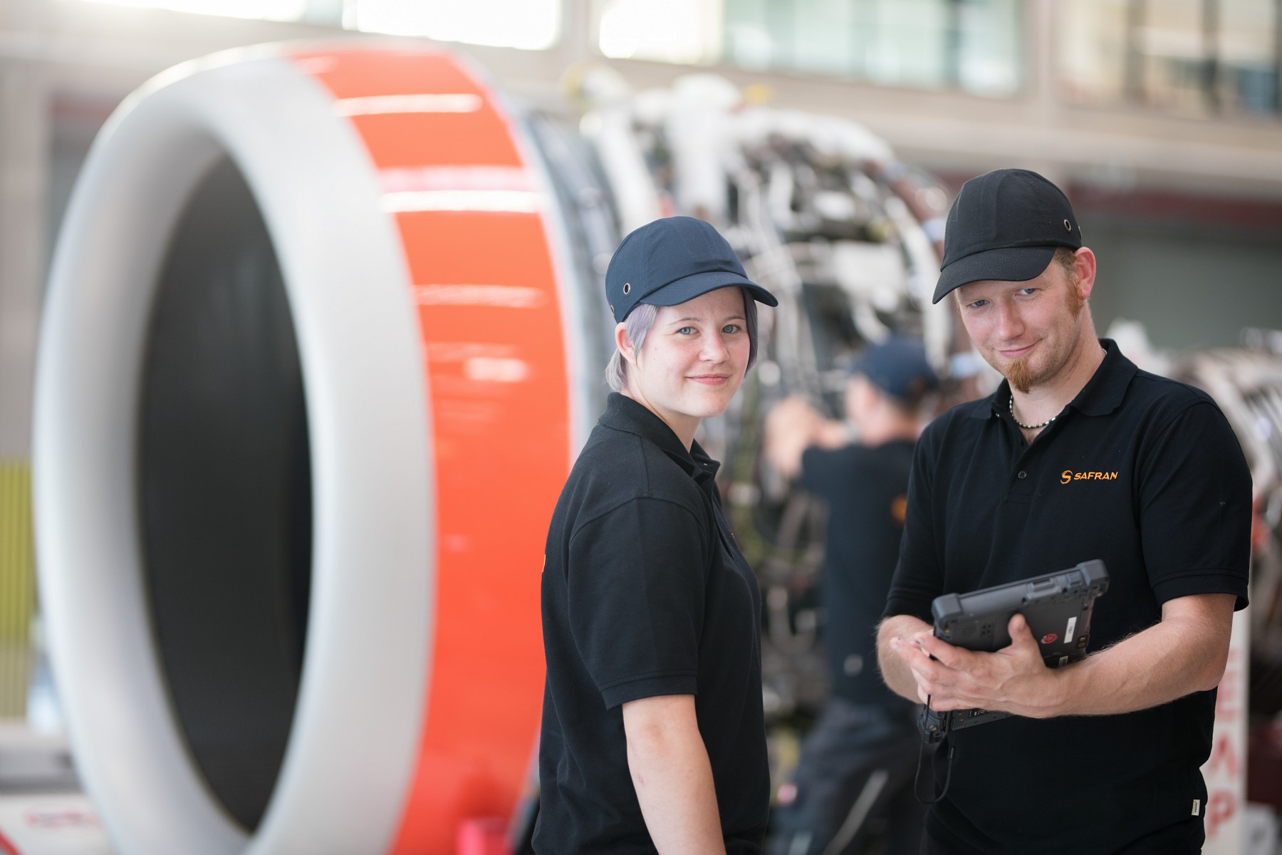 Employees of Safran standing with a blurred Nacelle in the background