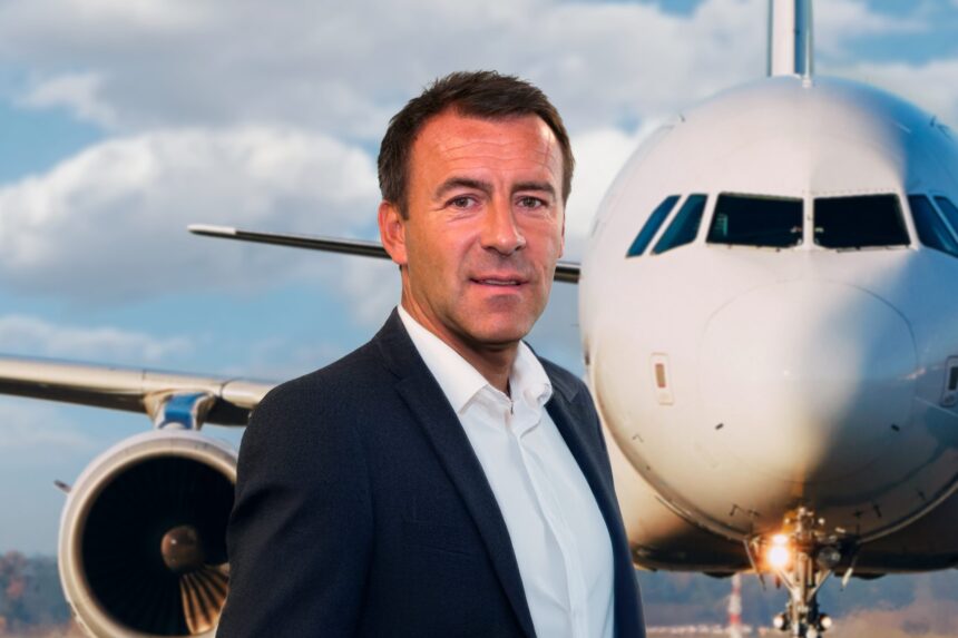Picture of Scott Collier, CEO of ACS, standing in front of an airplane.