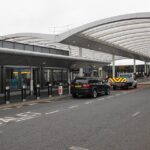 Car and truck parked in drop-off area at Gatwick airport.
