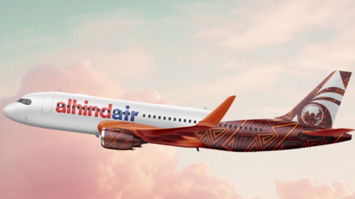 Al Hind Air airplane in flight, showing the airline’s logo font on the fuselage and a red flare design on the tail.