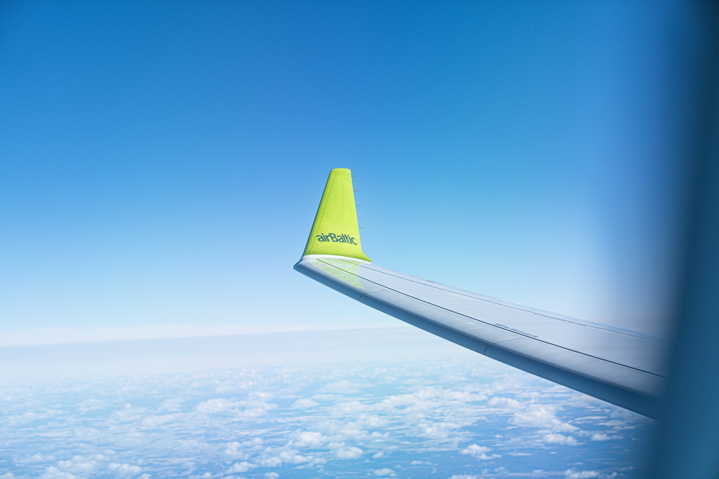 Winglet of an airBaltic Airbus A220-300 aircraft high above the clouds in Helsinki, Finland