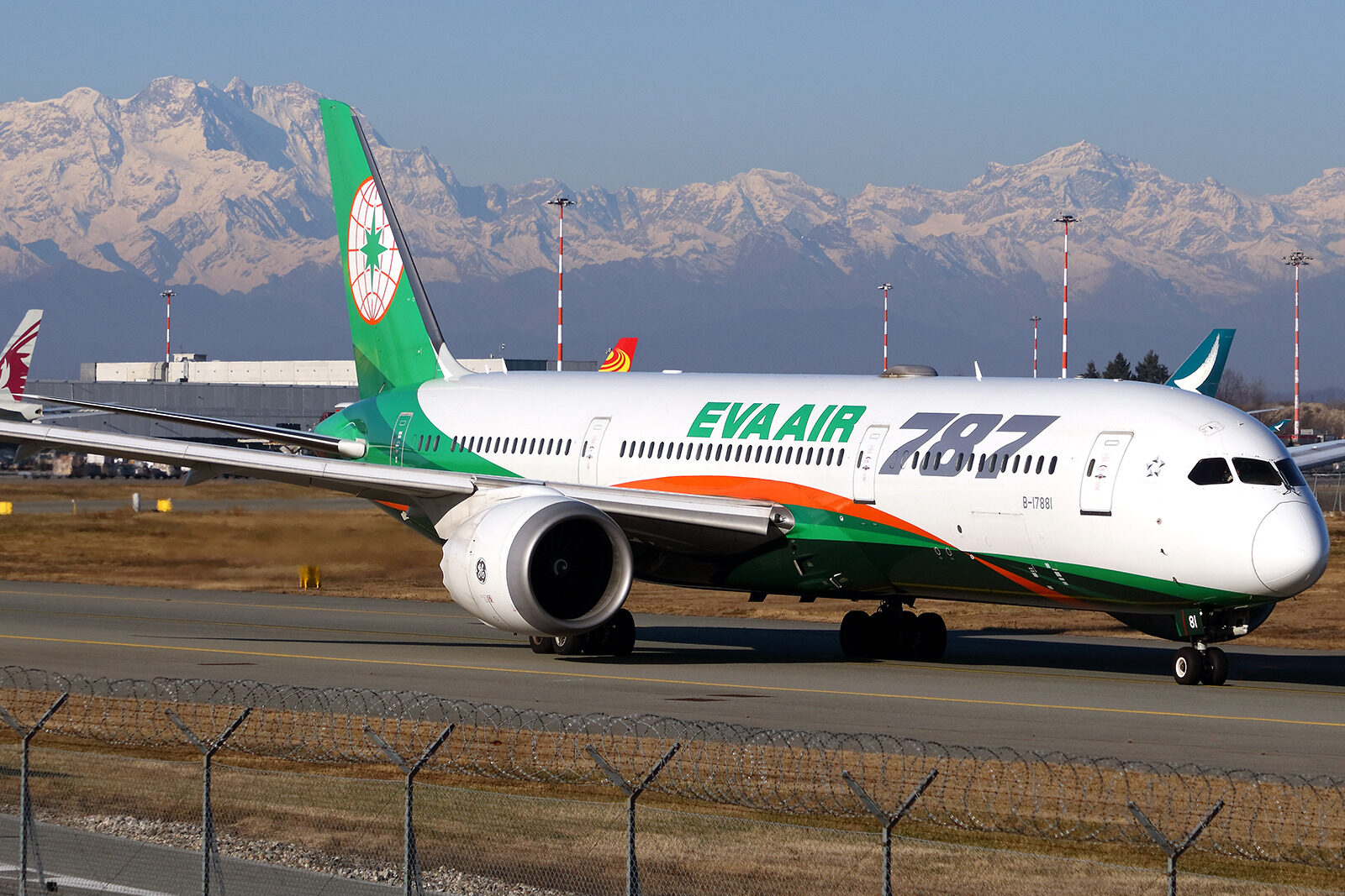 The Boeing 787-9 Dreamliner on the tarmac, showcasing green design elements and a globe logo.