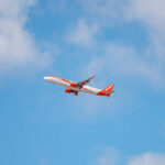 An easyJet plane flying against a blue sky.