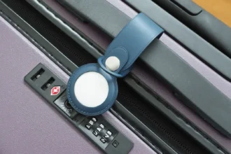 A picture of Apple's AirTag on a bag's handle bar.