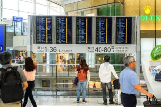 People Standing Near Airport Departure Board