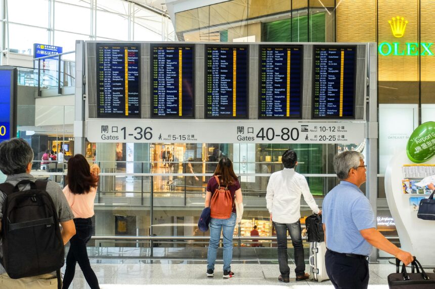 People Standing Near Airport Departure Board