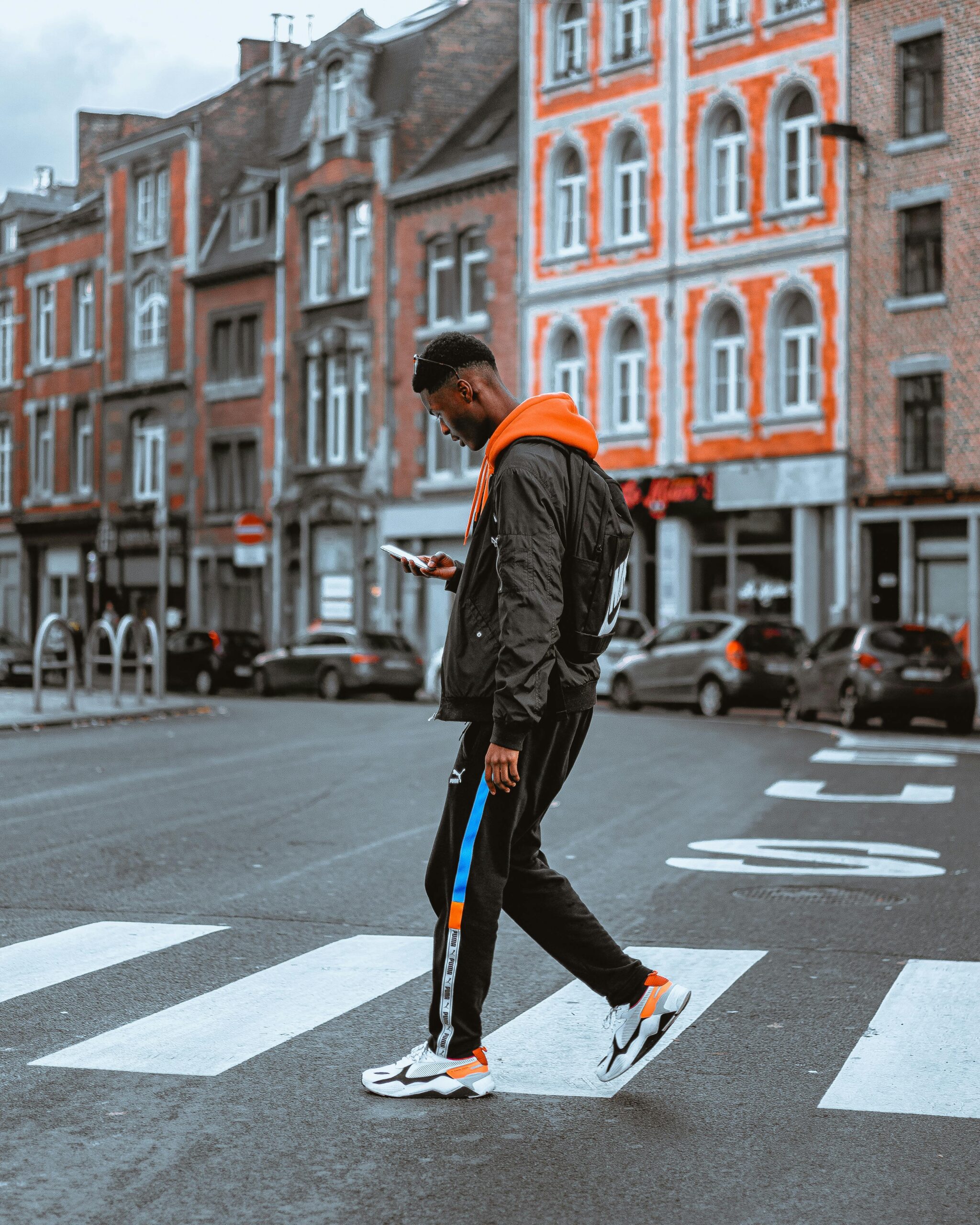 Man Crossing Road while loooking on his phone