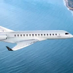 Bombardier Global 8000 ultra-long-range business jet flying over coastline, fastest business jet since Concorde