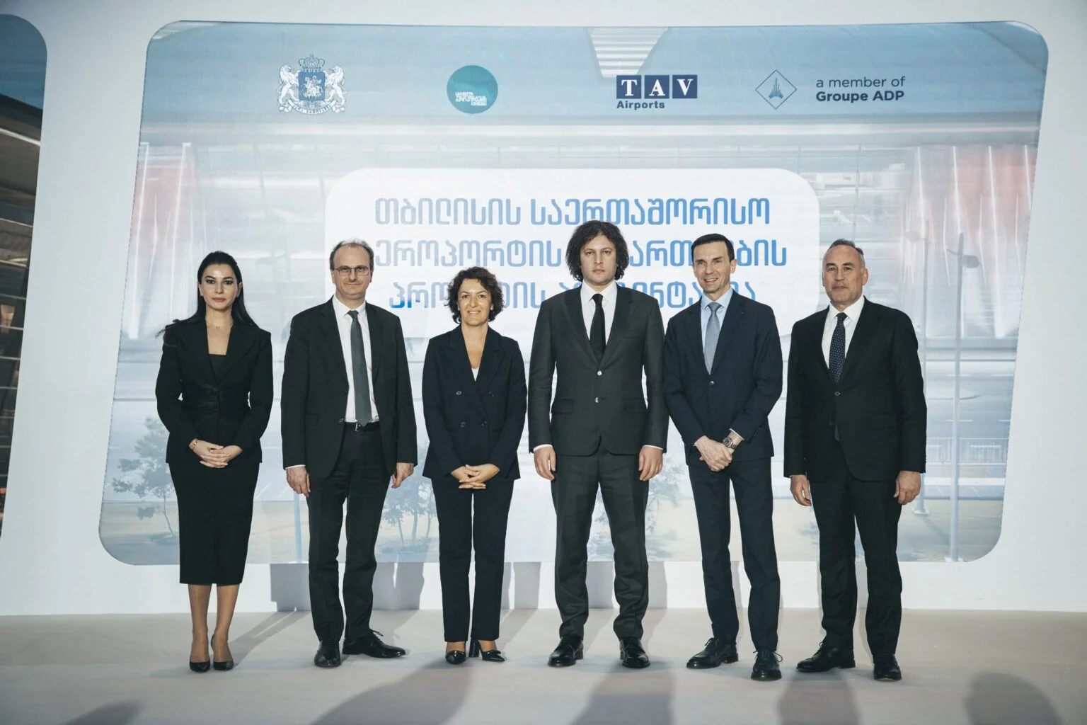 Six people stood in front of a blue background that says "TAV Airports"