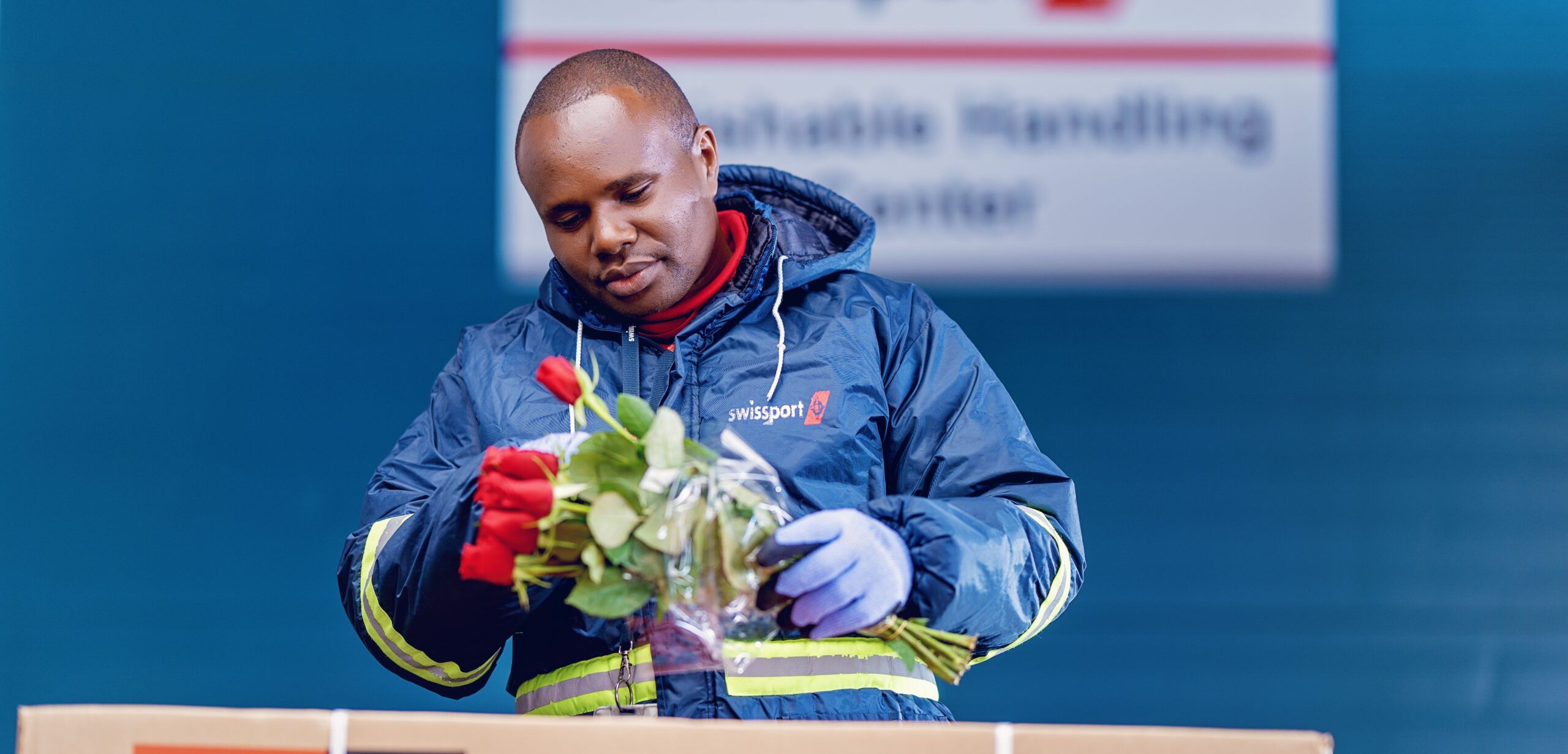 Swissport worker, handling red roses.