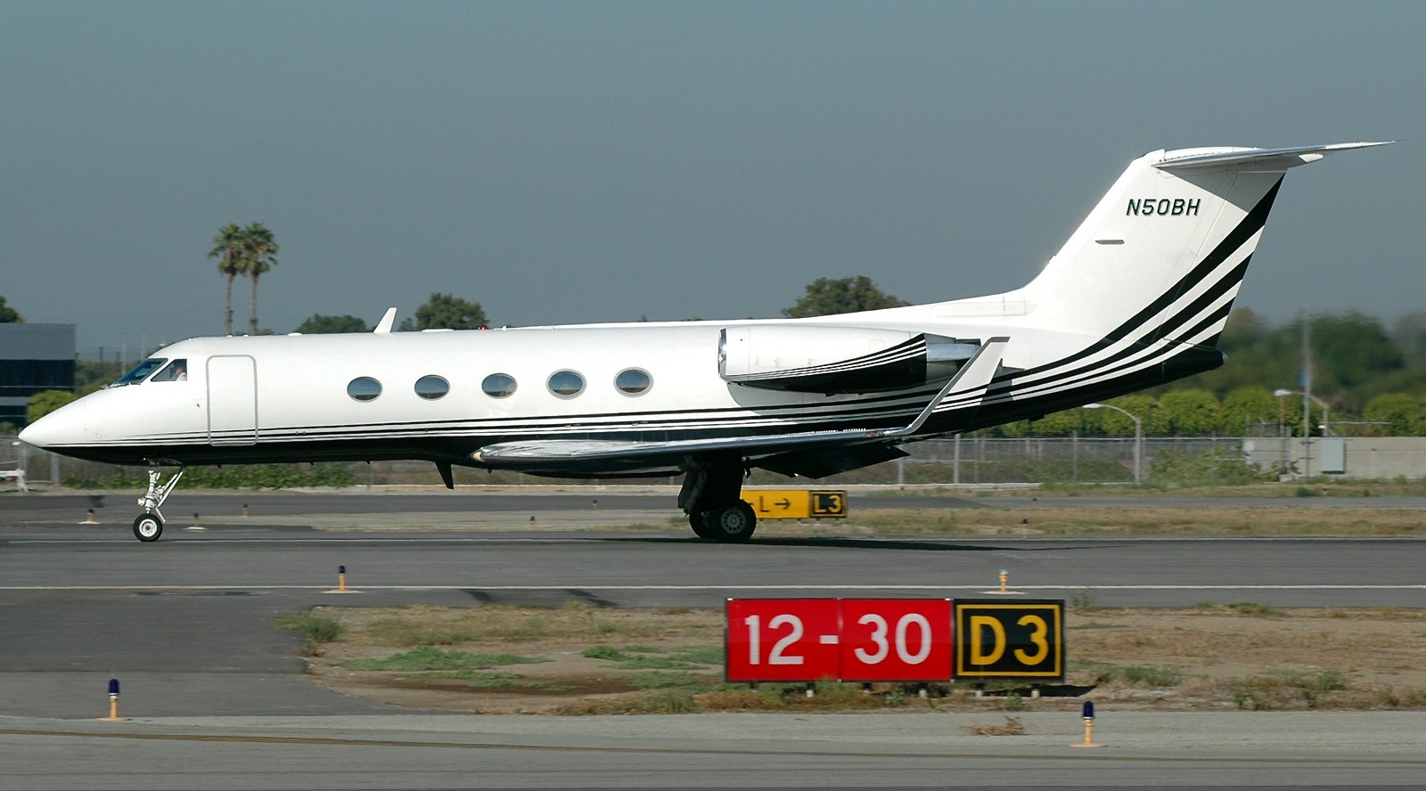 A white Gulfstream III, registered N50BH about to take off on the runway.