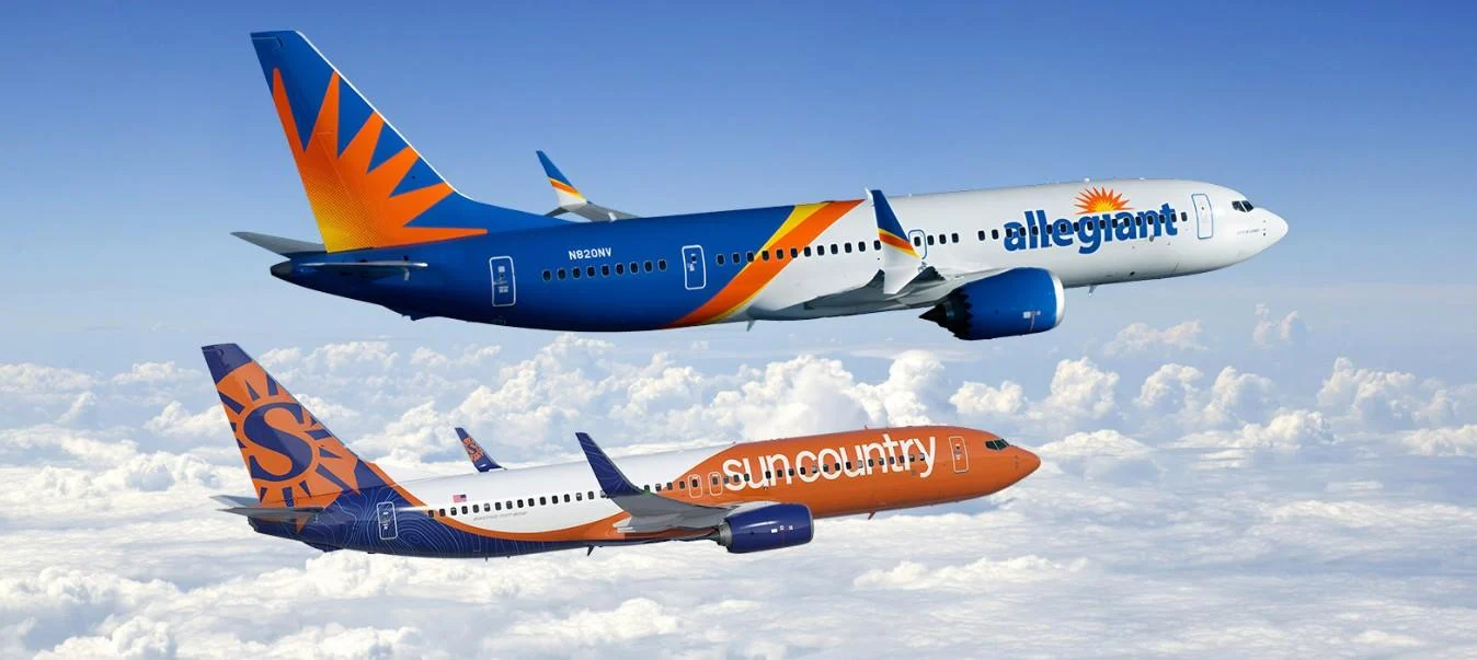 A Sun Country Airlines aircraft and an Allegiant Air aircraft side by side, both displaying similar orange and blue color schemes against the sky