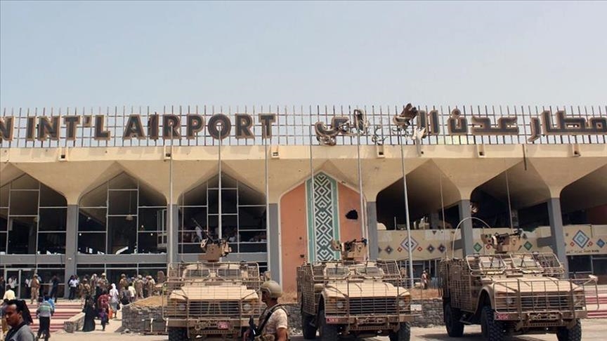 Front of Aden International Airport with three military vehicles outside and people walking around