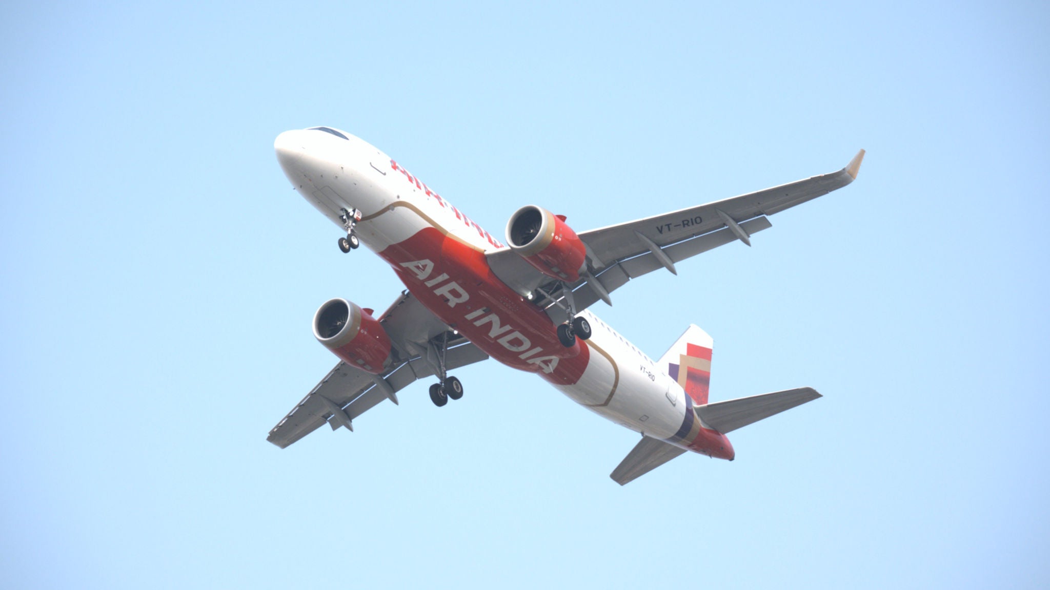 Air India A320 photographed from below showing the Air India logo on the belly of the aircraft.