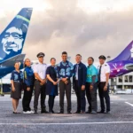 Alaska Airlines crew with Hawaiian Airlines crew in front of aircraft.