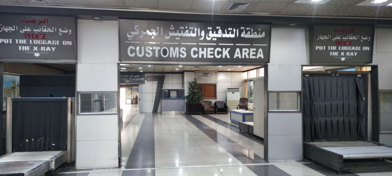 'Customs Check Area' is written in English and in Arabic inside the Aleppo Airport.