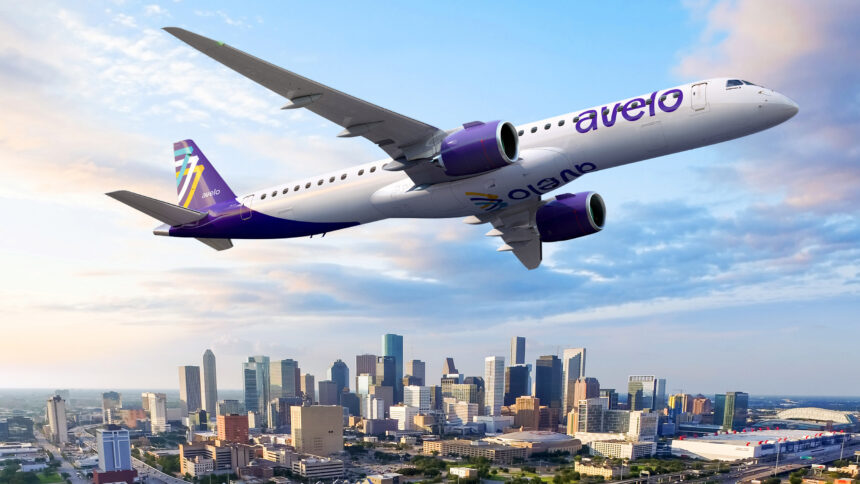 An Avelo Airlines aircraft flies over Houston’s skyline, with blue skies and downtown skyscrapers visible below