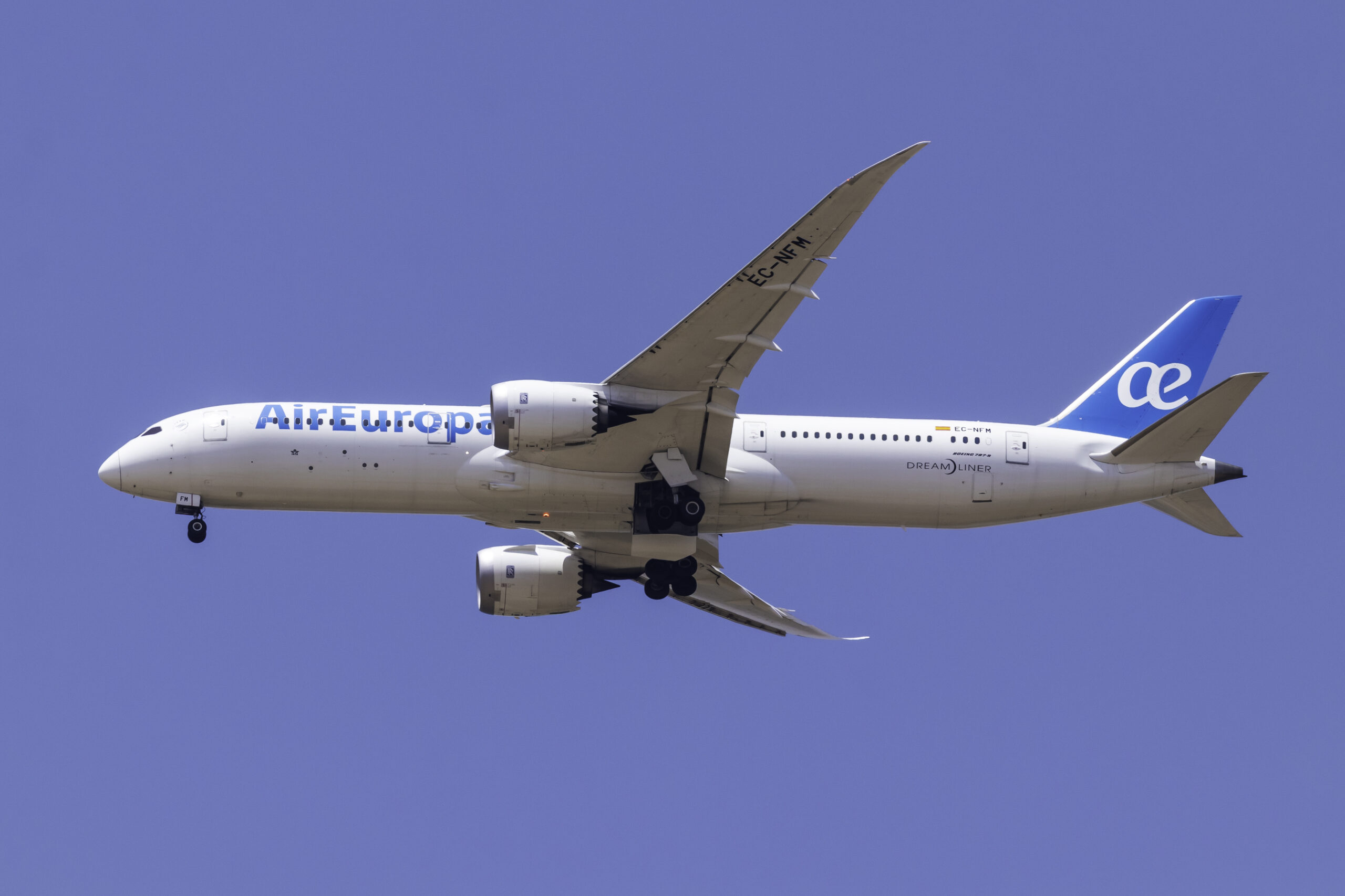 Air Europa 787 Dreamliner mid flight against a bright blue sky.