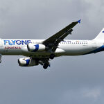 A320 by FlyOne Armenia flies with clouds in the background.