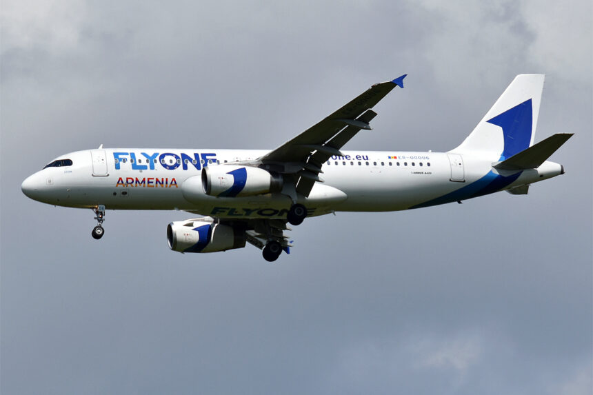 A320 by FlyOne Armenia flies with clouds in the background.
