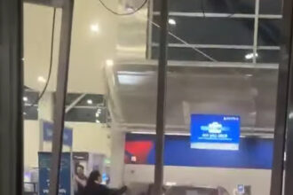 A black Mercedes sedan crashed inside Detroit Metro Airport's terminal, surrounded by debris from a shattered ticket counter.