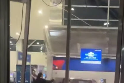 A black Mercedes sedan crashed inside Detroit Metro Airport's terminal, surrounded by debris from a shattered ticket counter.