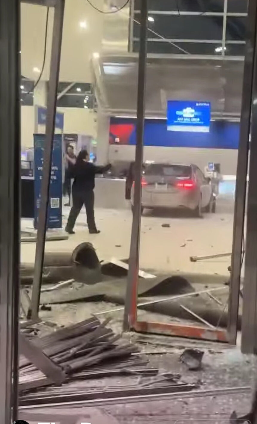 A black Mercedes sedan crashed inside Detroit Metro Airport's terminal, surrounded by debris from a shattered ticket counter.