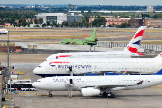 Passenger jetliners are parked on Heathrow Airport's tarmac.