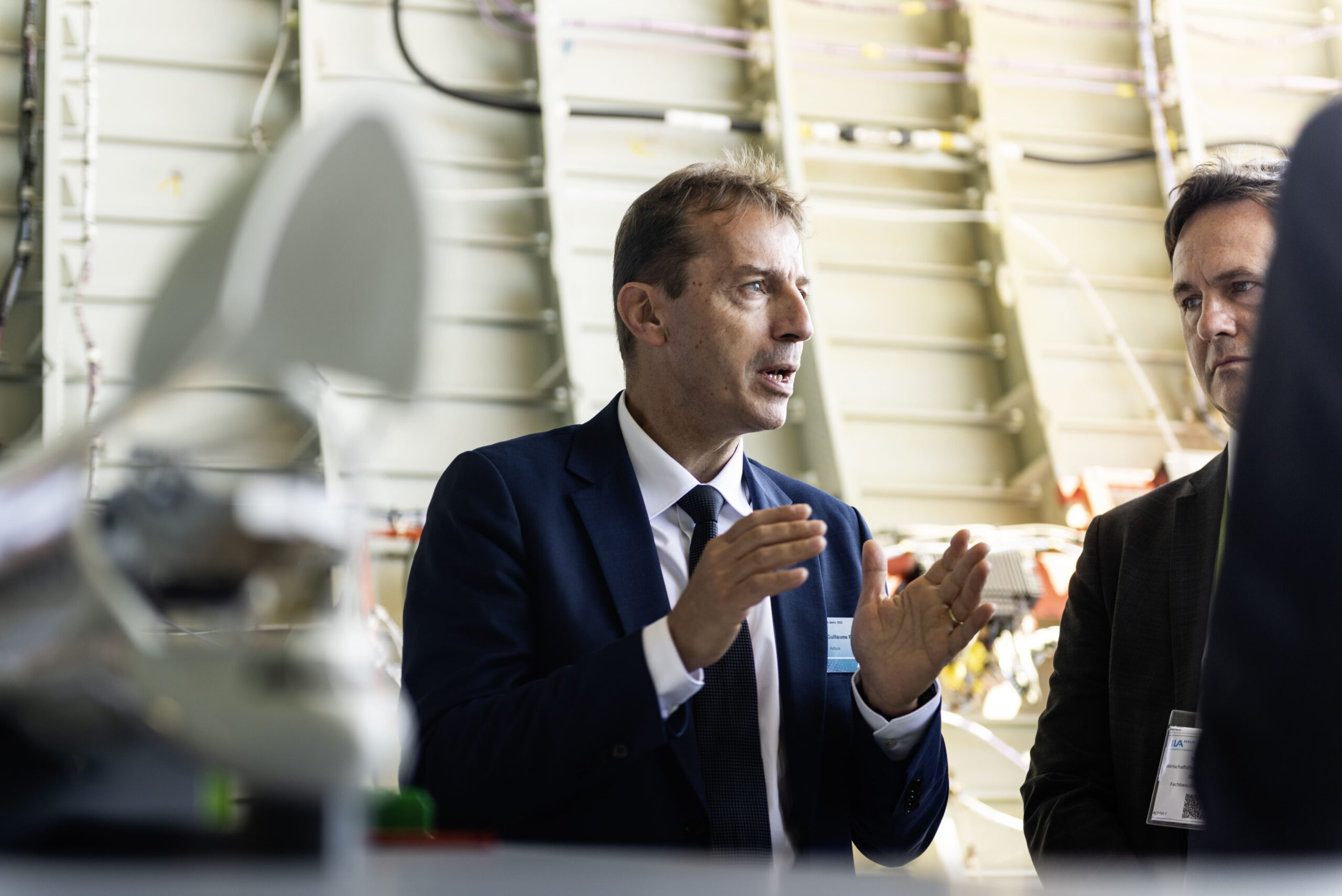 Guillaume Faury with Michael Kretschmer, Prime Minister of Saxony, at the ILA Berlin Air Show of 2022, inside a hangar.