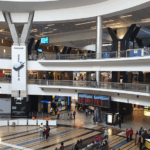 Interior of O.R. Tambo International Airport in Johannesburg, showing a spacious terminal with high ceilings and travelers moving through the concourse.