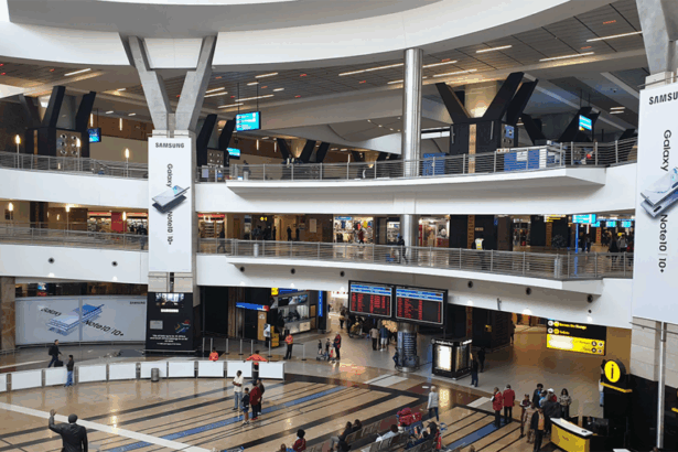 Interior of O.R. Tambo International Airport in Johannesburg, showing a spacious terminal with high ceilings and travelers moving through the concourse.