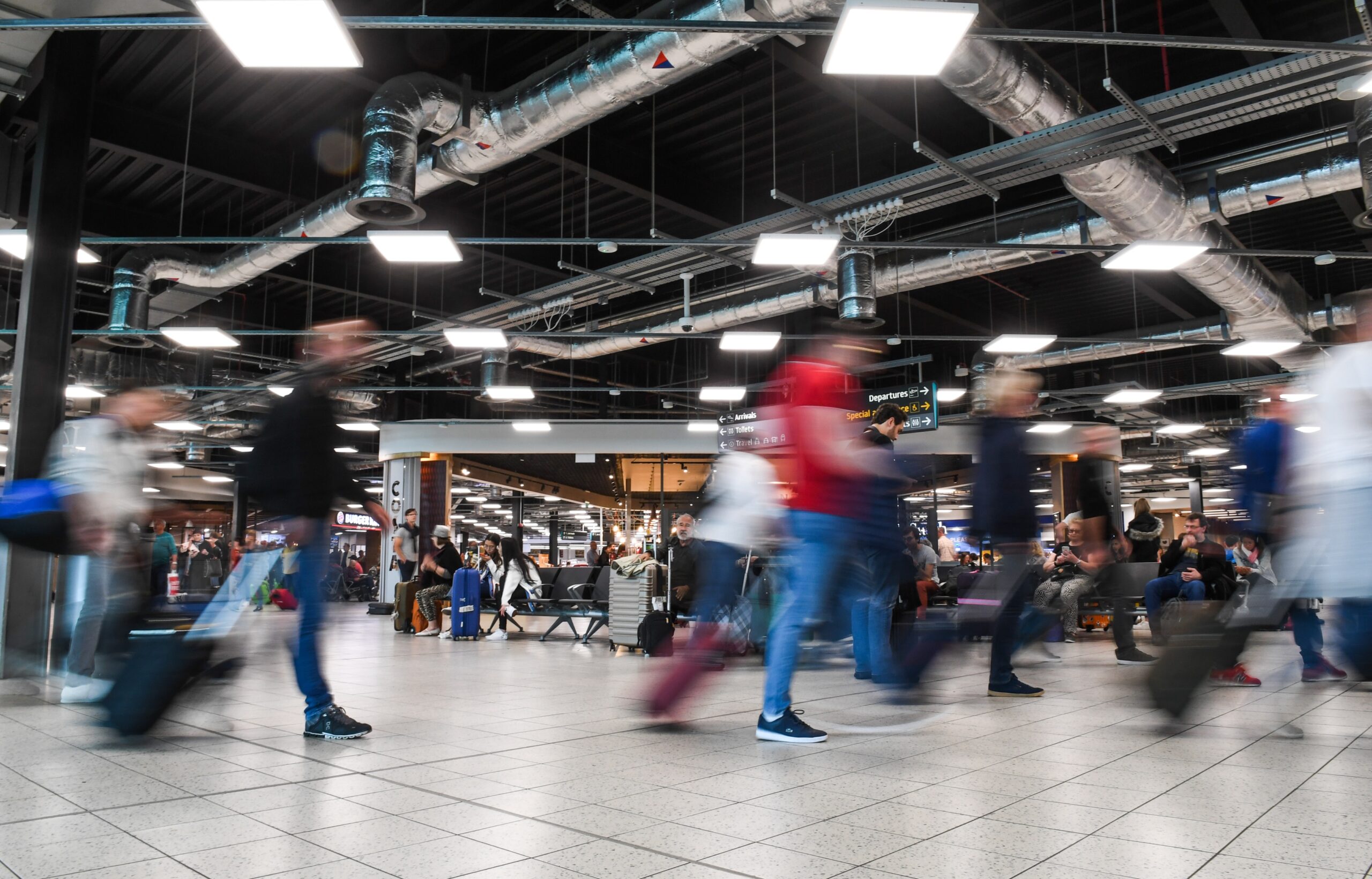 London Luton Airport, busy, blurred people as they walk past.